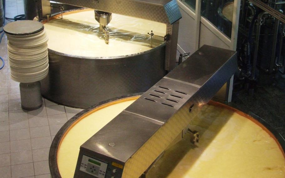 Gruyère cheese in the making in Gruyère, Switzerland. Rotating blades cut the curdled mass, which is then heated. Once the particles have dried, the mass is poured into molds.