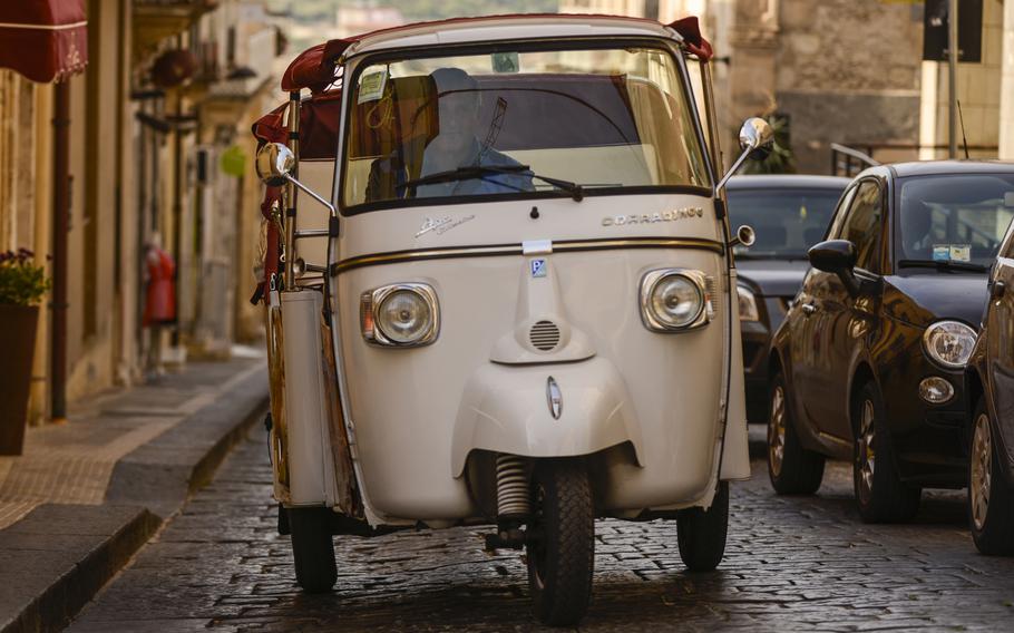 A tour guide in Noto, Sicily, drives his Piaggio Ape, a three-wheeled, light commercial vehicle first produced in 1948.