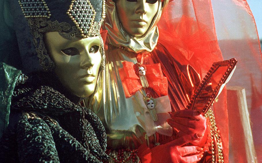 Revelers in elaborate costumes pose for photographers willingly during Carnevale in Venice. Being seen but not known is what the pre-Lenten celebration is all about.