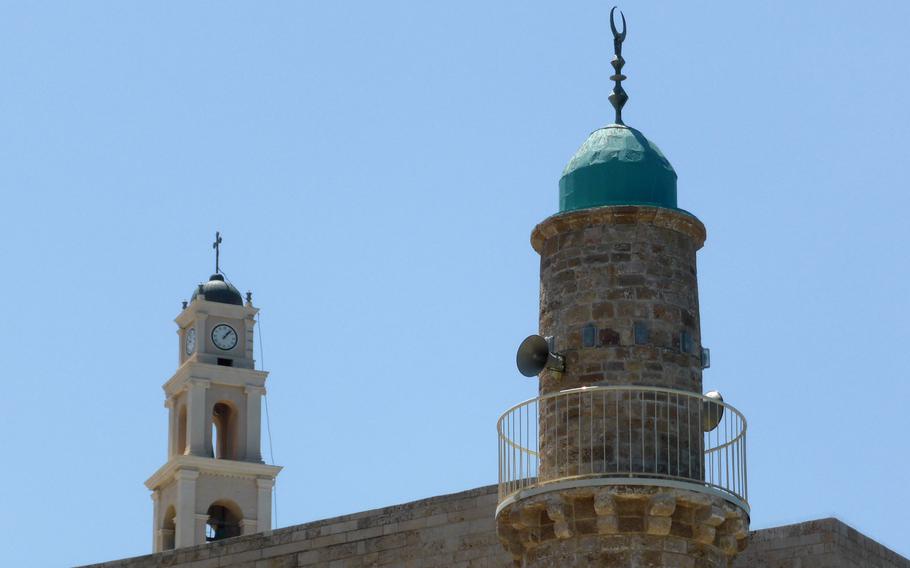 A minaret of the Sea Mosque and the steeple of the Franciscan Church of St. Peter share the sky in Jaffa, Israel.