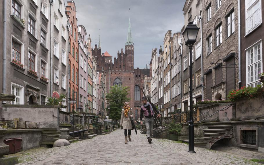 Artists walk down one of  Gdansk, Poland's most beautiful thoroughfares, Mariacka Street, a secluded lane with a charming atmosphere.