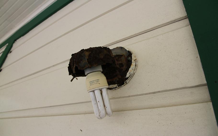 A light fixture rots off the wall on the front porch of the replica of President William Jefferson Clinton's birthplace home in Nago, Okinawa. The home, which cost just shy of a $1 million 14 years ago, today is a day care facility sliding into neglect and decay.