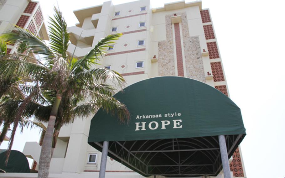 An awning on a nearby building provides one of the only signs to confirm that a nearby American-style home is in fact an exact replica of President Clinton's boyhood home from Hope, Ark.