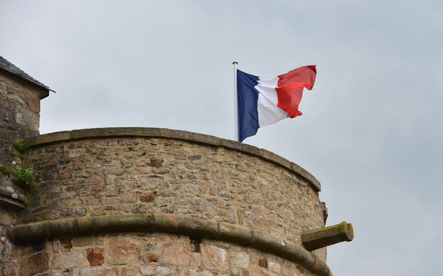 A French flag flies from the Tour du Roi at Mont-St-Michel, France. The old fortified abbey and town, on an island just off the Normandy coast, is a popular tourist destination.
