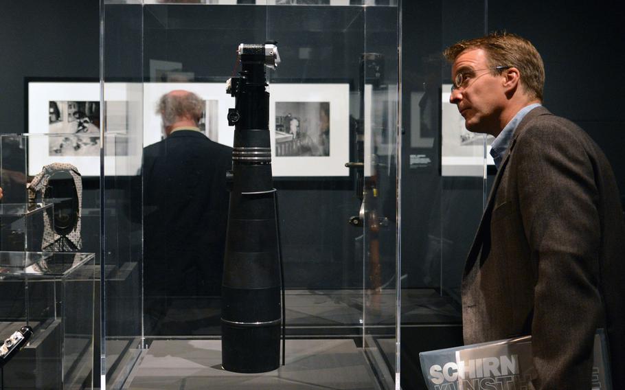 A visitor to the new exhibit "Paparazzi Photographers, Stars and Artists" at the Schirn takes a look at a paparazzo's tool, a camera with a 1000mm telephoto lens.  