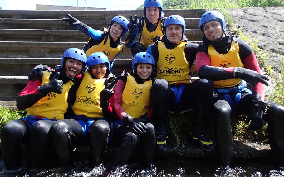 A tour group poses with satisfied smiles after a day of canyoning in Gunma, Japan.