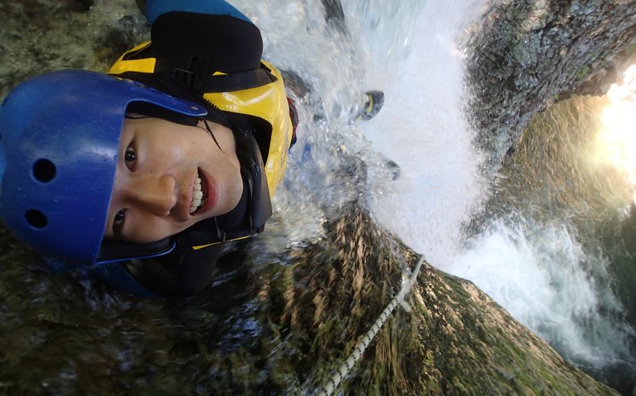 A Japanese thrill-seeker gets ready to slide down a waterfall during a canyoning tour in Gunma, Japan. Adventurers can chose between canyoning, rafting and nature tours.