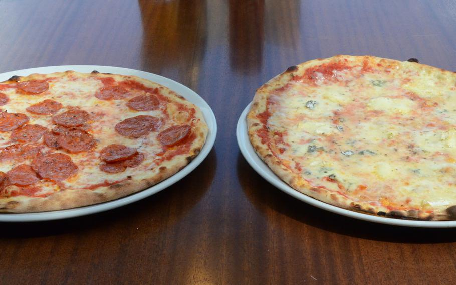 A "diavola pizza," shown topped with spicy salami and mozzarella, is accompanied by a "quattro formaggi" pizza topped with a  light covering of tomato sauce, mozzarella, blue cheese, brie, an Italian soft cheese and oregano. The pizzas made for a filling lunch for two at Ristorante Pizzeria Doria in Orsago, Italy.