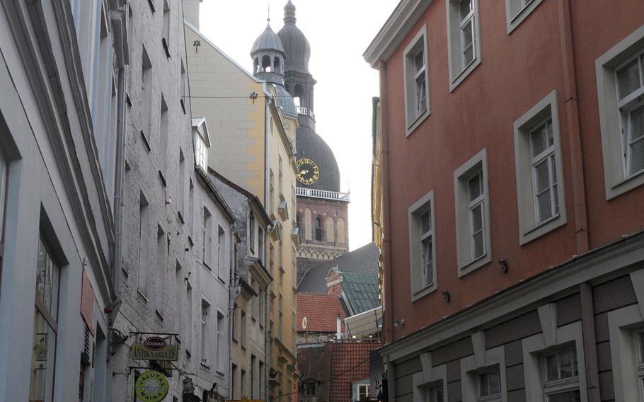 Riga Cathedral peeks through a twisting alley in the capital's old town. Just visible at the top of the bell tower is a small, golden rooster, a common icon  placed atop churches here to ward off evil.