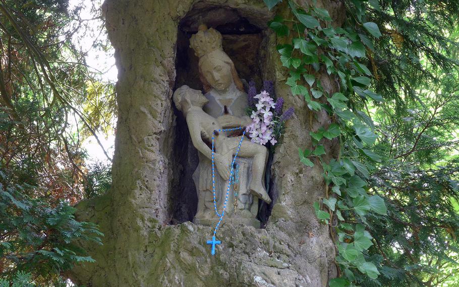 A sculpture of "Unsere Liebe Frau mit den Pfeilen," or Our Dear Lady with the Arrows" stands in the crook of a tree in the cloister park in Blieskastel, Germany. The original is in the nearby Holy Cross Chapel, a place of pilgrimage.