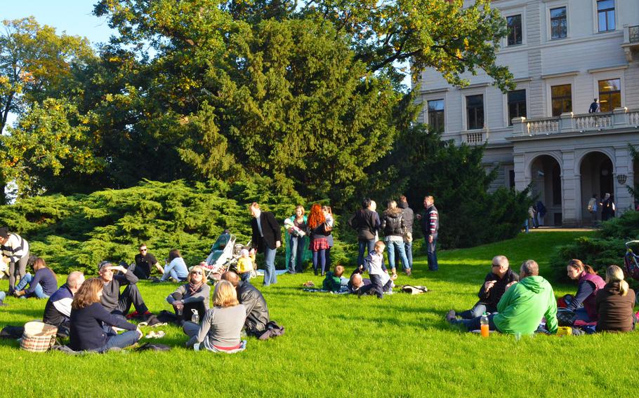 Festival goers enjoy the sun and the wine on the lawn outside the Grobe villa at the 2013 Vinobrani na Grebovce in Prague.