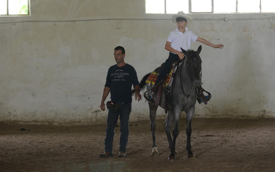 Riding instructor Ivan Ceolin shows how a stirrup should be positioned with the help of one of his students during a lesson at Agriturismo al Ranch in Budoia, Italy. 