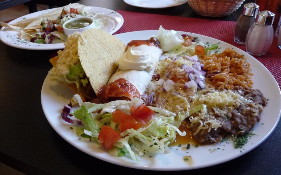 A three-item combination plate at Primavera Mexican Restaurant consisting of a beef taco, a burrito and an enchilada, served with rice and refried beans.