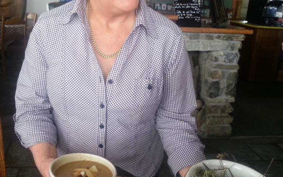 The proprietor of Chez Coquoz, Agnes Coquoz, serves her special of the day: hay soup, made of dried mountain grass and herbs. Coquoz is a former member of the Swiss Olympic ski team.