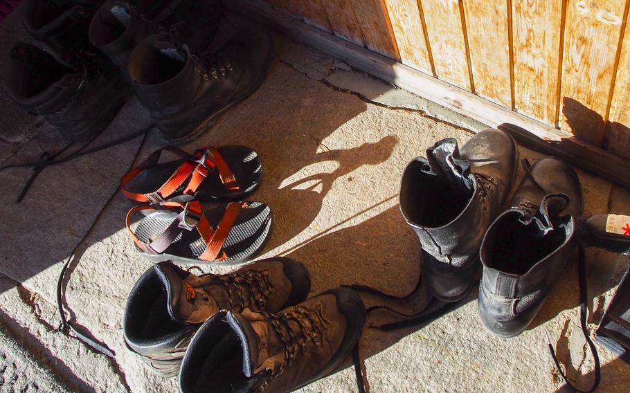 The orange Chaco sandals that earned photographer Joshua L. DeMotts the nickname "Chaco Libre" rest next to the normal bulky hiking boots in the entrance to the Reinheim hut in Dovrefjell National Park, Norway.
