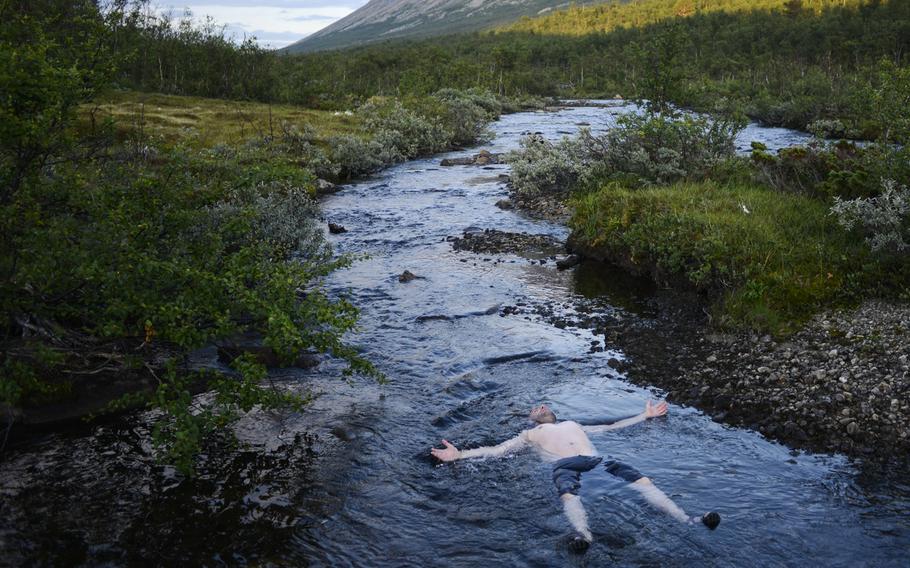 Stars and Stripes photographer Joshua L. DeMotts soaks in a cold stream after a long day of hiking in Dovrefjell National Park.