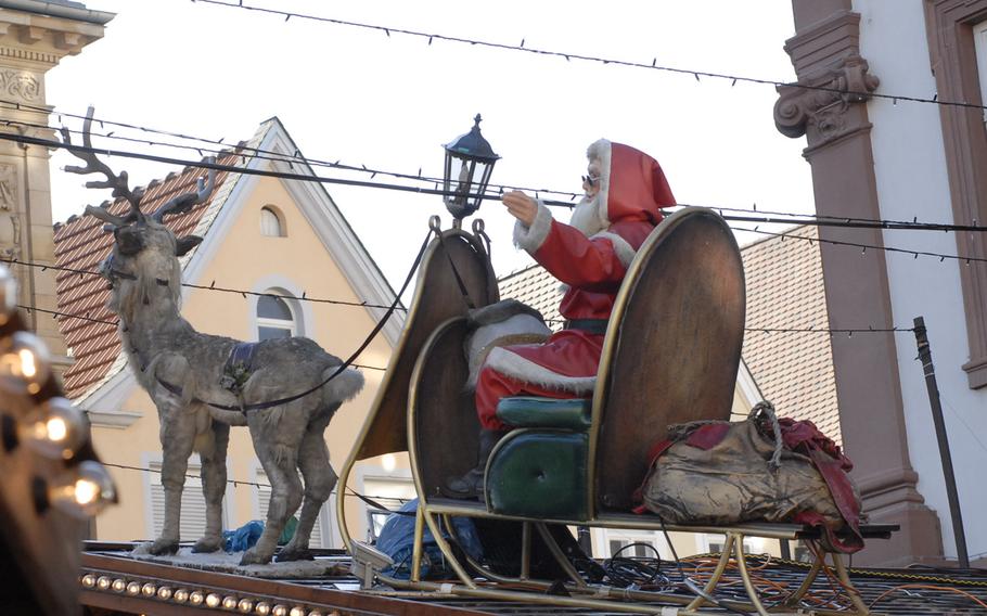 Santa Claus waves from a rooftop at the Speyer Christmas Market, in Speyer, Germany, in December 2013.