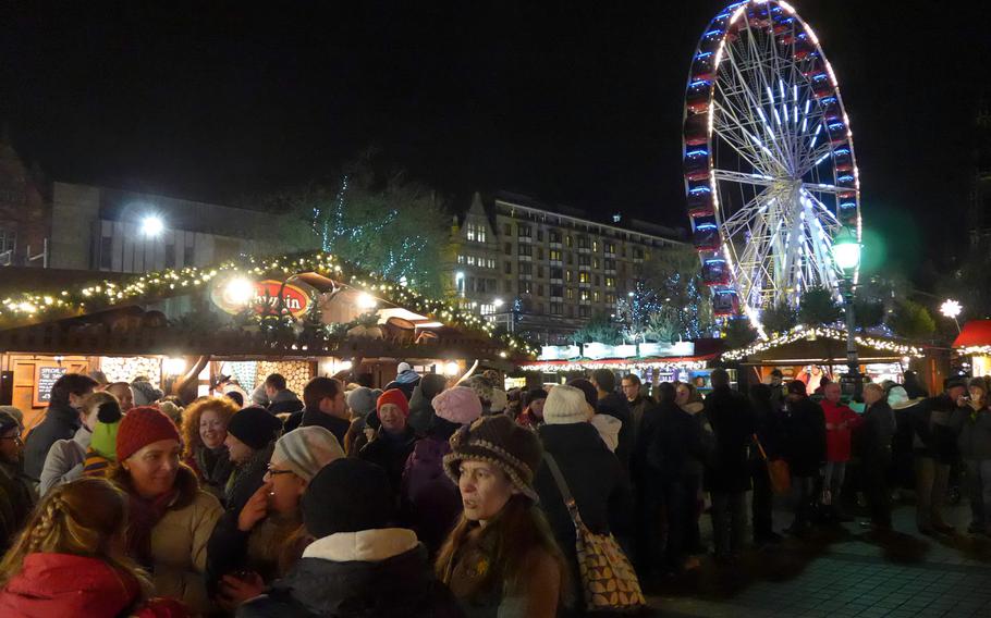 Visitors enjoy food, drink and the company of friends at the European Christmas Market in Edinburgh, Scotland.