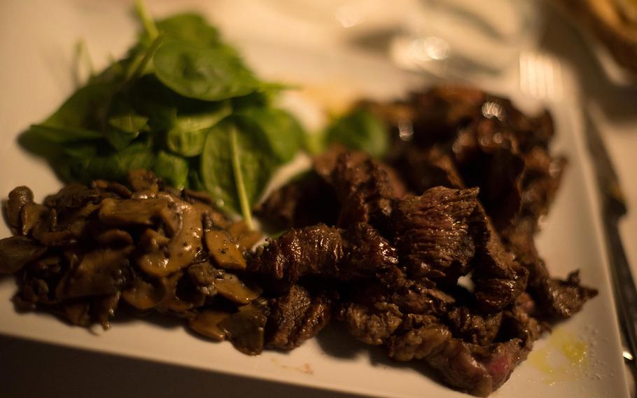 Argentine beef tips at the restaurant Panart in Carinaro, Italy, just outside the U.S. naval base support site in the Naples area. The dish is served with sides of saut?ed mushrooms and a bed of baby spinach.