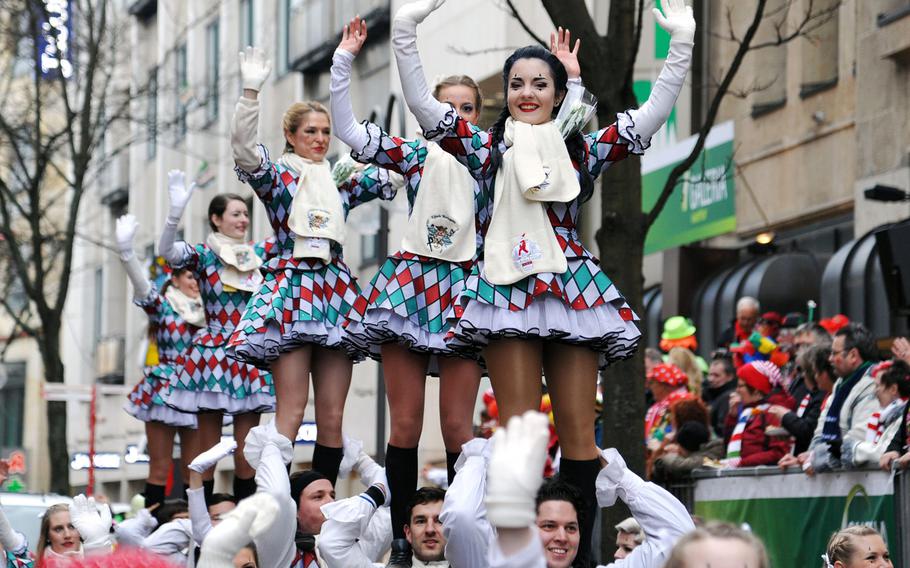 The dancers of a carnival dancing club ride on the shoulders of their male club mates during the 2014 Cologne Rose Monday parade. 