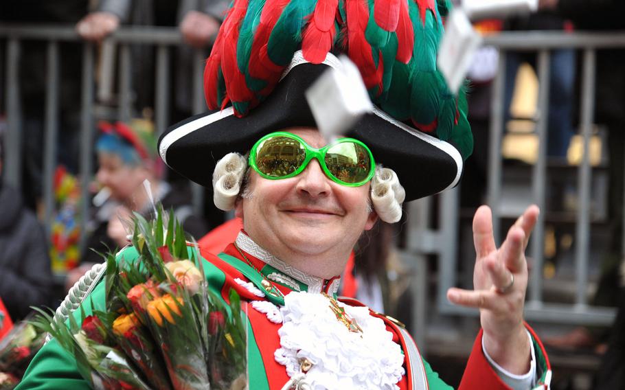 A participant in the 2014 Cologne Rose Monday parade tosses candy to the spectators lining the streets. It is estimated that around 300 tons of sweets are thrown by the participants.
