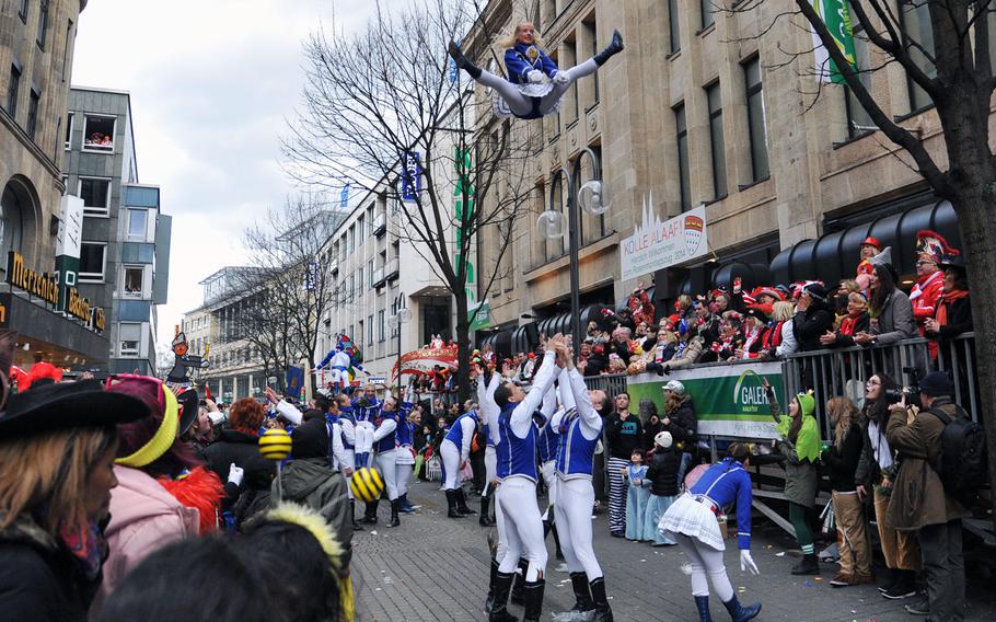 Dancers in a Carnival dancing club are tossed into the air by their male club mates during the 2014 Cologne Rose Monday parade.