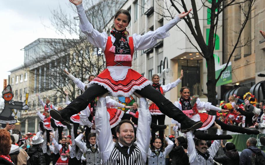 Dancers with a Carnival dance group are carried by their male club mates during the 2014 Cologne Rose Monday parade. It is not unusual for the girls to be tossed high in the air along the parade route.
