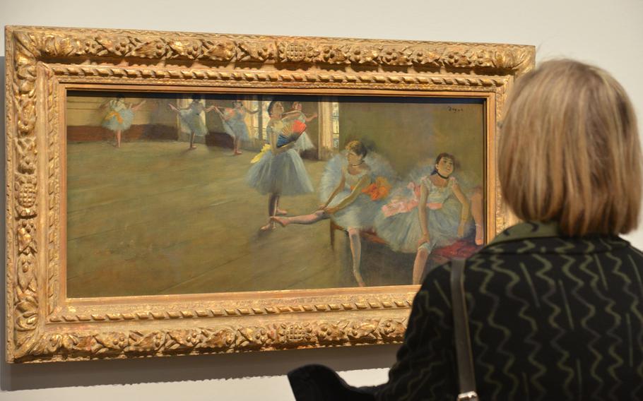 A visitor to the "Monet and the Birth of Impressionism" exhibit at the Städel in Frankfurt, Germany, gets a closer look at Edgar Degas' "Dancers in the Classroom" from about 1880.