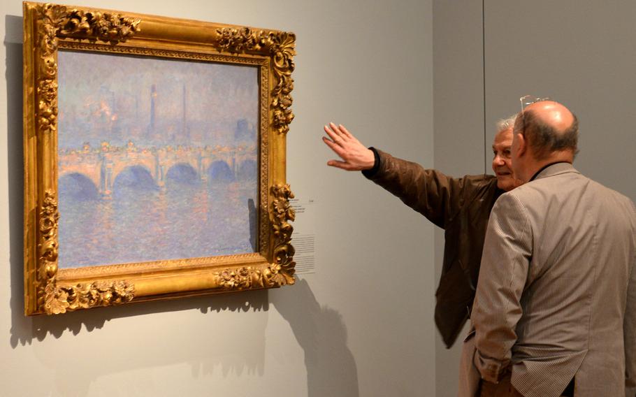 Visitors to the "Monet and the Birth of Impressionism" exhibit at the Städel in Frankfurt, Germany, discuss the artist's "Waterloo Bridge, Sunlight Effect" from 1899-1901.