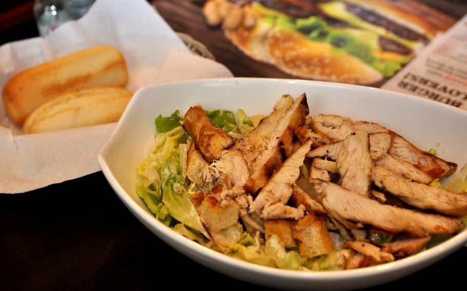 The chicken Caesar salad at Roadhouse Grill is loaded with chicken. A pair of rolls comes along as a side.