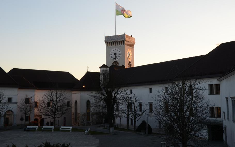 Visitors atop Ljubljana Castle's tower enjoy a view of the sun as it sets over Slovenia's capital.