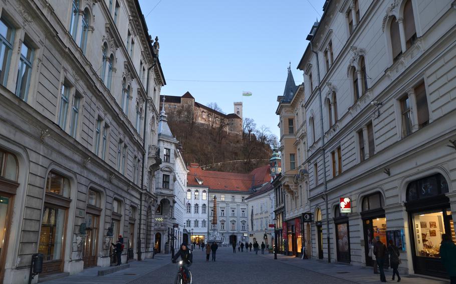 Pedestrians fill streets lined with shops just below Ljubljana Castle in the central part of Ljubljana, Slovenia.