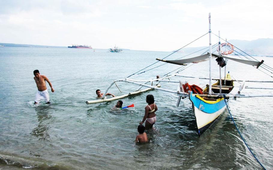 A Filipino family swims at Baloy Beach in Subic Bay in March 2015.