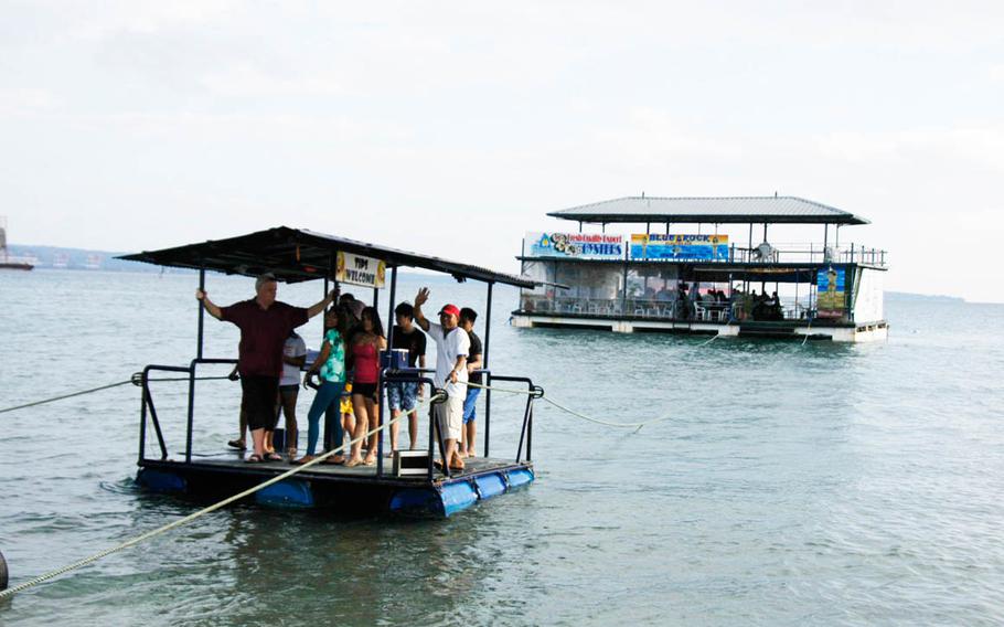 Visitors ride a barge back from a floating bar at Baloy Beach in the Philippines in March. Seth Robson/Stars and Stripes