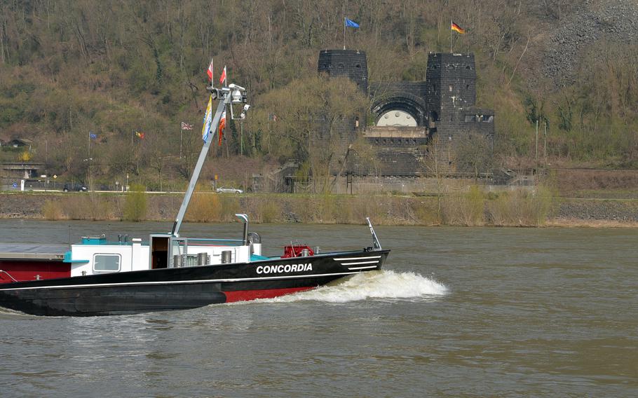 A ship plies the Rhine River passing the towers of the former Ludendorff Bridge on the west bank of the Rhine near Erpel, Germany. The structure and a similar one on the east bank at Remagen are all that is left of the bridge, destroyed in World War II. The white half circle was a railway tunnel. The structure on the west bank houses the Peace Museum.