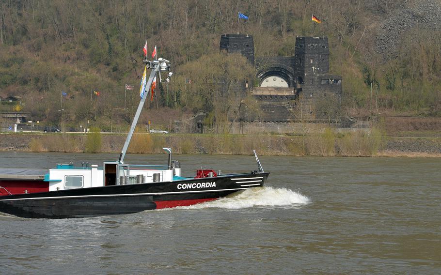 A ship plies the Rhine River passing the towers of the former Ludendorff Bridge on the west bank of the Rhine near Erpel, Germany. The structure and a similar one on the east bank at Remagen are all that is left of the bridge, destroyed in World War II. The white half circle was a railway tunnel. The structure on the west bank houses the Peace Museum.