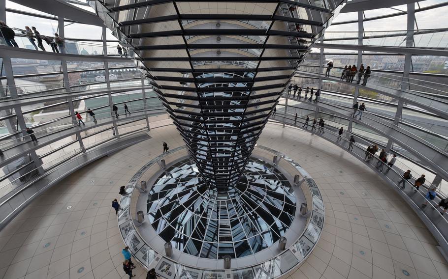 Looking down to the floor of the Reichstag cupola. Ramps lead up and down around the cupola, offering a 360-degree view of Berlin. The history of the building can be read on the panels that circle the base of the central  mirrored cone, which can be used to draw light into the plenary chamber below.