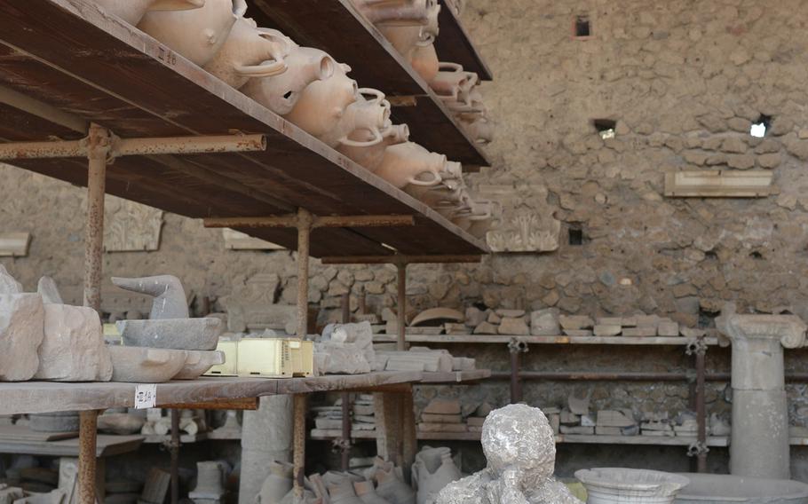 A plaster cast model of one of ancient Pompeii's victims sits among objects excavated at the site of the destroyed city. The recently restored Villa dei Misteri, a luxurious former summer home outside the city's ancient gates, reopened to visitors in spring 2015.