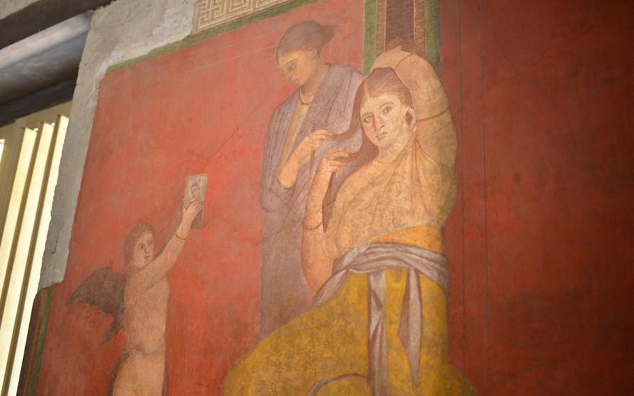 The dining room fresco at the recently restored Villa dei Misteri in Pompeii extends across three walls and offers a vivid portrayal of ancient Romans in celebration and ritual. Here, a woman has her hair styled. The villa reopened for visitors in spring 2015.