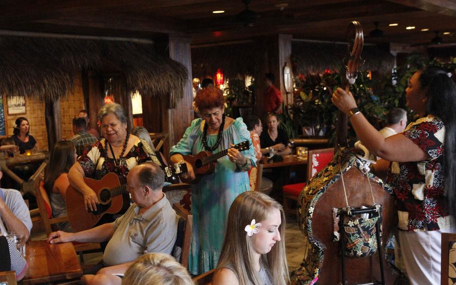 The Hawaiian music comes to you at Duke's Waikiki. A three-piece band strolls among customers during a recent weekday dinner.