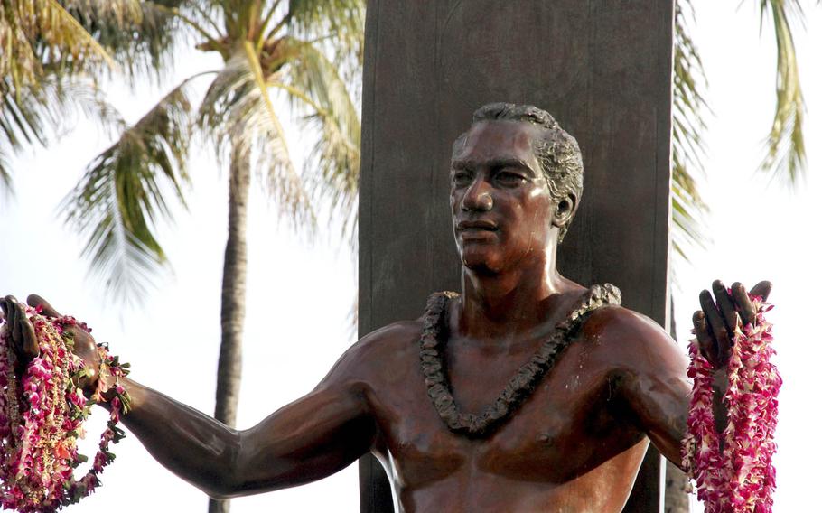A bronze statue of Duke Kahanamoku, the father of modern surfing, looms over visitors at Waikiki Beach.