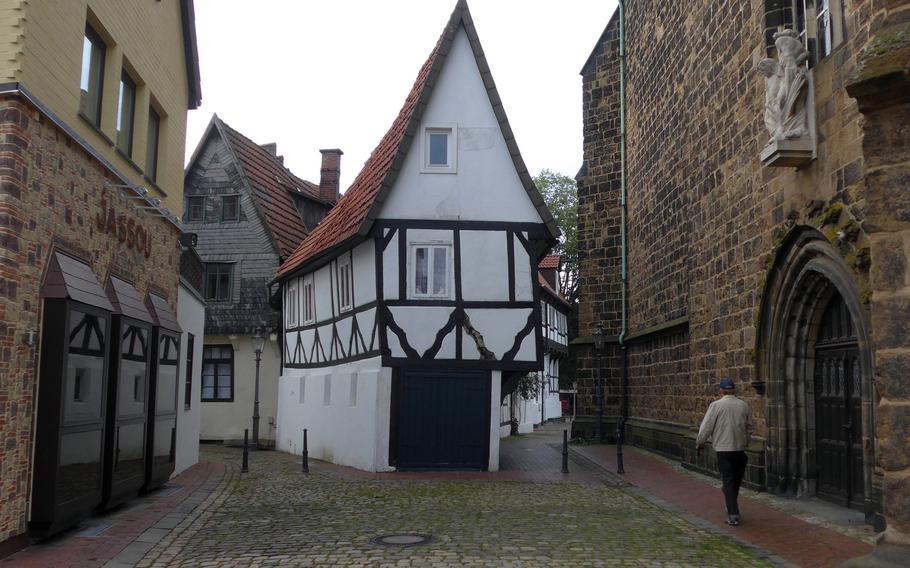 Hohestrasse in Minden, Germany, with an interestingly shaped half-timbered house at center and St. Martini Church on the right. A statue of St. Martin saving the beggar can be seen above the portal