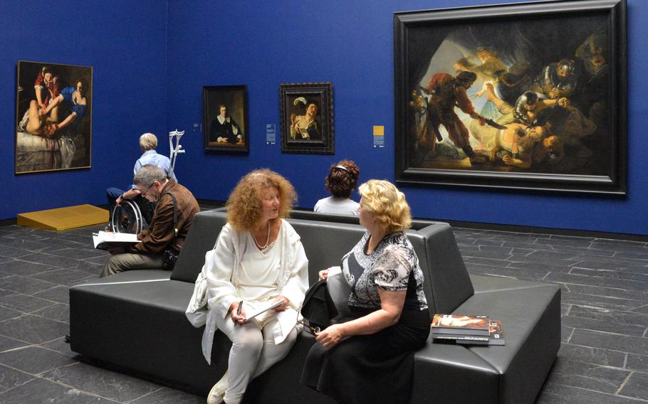 Visitors to the "Masterworks in Dialogue" exhibit at the Staedel in Frankfurt, Germany, discuss and view the art on display. To celebrate its 200th anniversary, the museum brought masterpieces from other museums and collections to display with works of its own. At left is Artemisia Gentileschi's "Judith Slaying Holofernes" from the Museo e Gallerie Nazionali di Capodimonte, Naples, Italy, and at right the Staedel's "The Blinding of Samson" by Rembrandt van Rijn.
