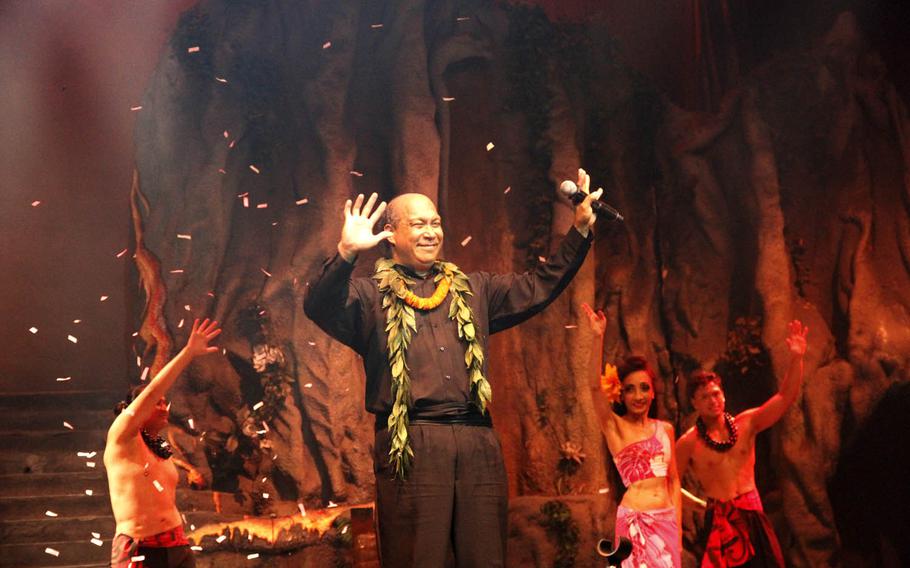 Magician Michael Villoria waves to the audience after completing a confetti-spewing illusion toward the end of the Magic of Polynesia show in Honolulu.