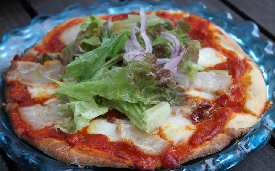 Fuu Cafe on Sesoko Island in northern Okinawa, Japan, offers a delicious agu pork uncured ham pizza with a crispy crust, vibrant sauce, fresh cheese and tender meat topping.