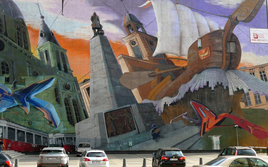 A giant mural decorates the wall of a building just off Piotrkowska Street in Lodz, Poland. The pedestrian street, called "P Street" by Americans at nearby Lask Air Base, features many statues and impressive architecture along with shops, bars and restaurants.