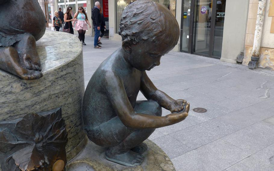 A statue of a little boy adorns a fountain on Piotrkowska Street in Lodz, Poland. A couple of these fountains featuring statues of children can be found along the street, Lodz's main pedestrian shopping lane.