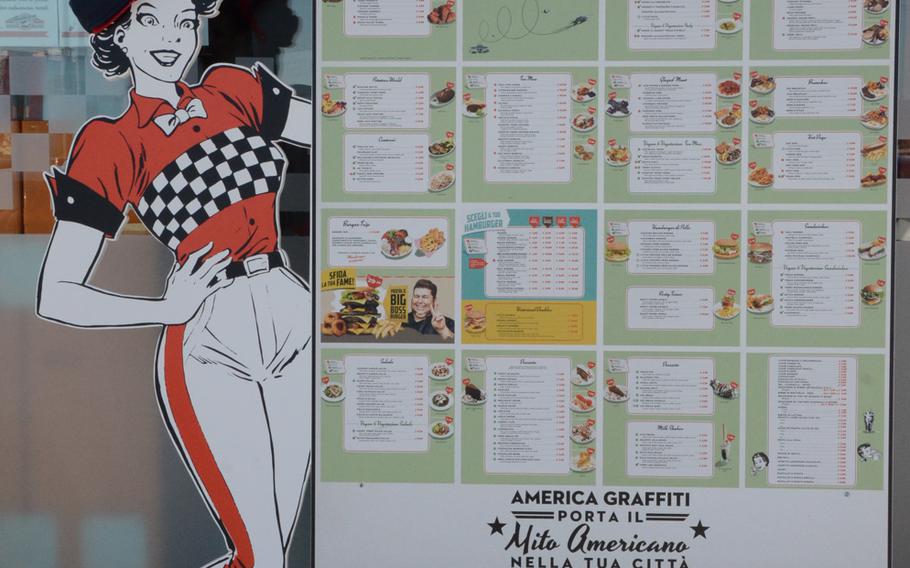 A cutout of a hostess displays part of a 35-page menu outside the entrance to  America Graffiti, a 1950s-style diner in Pordenone, Italy.