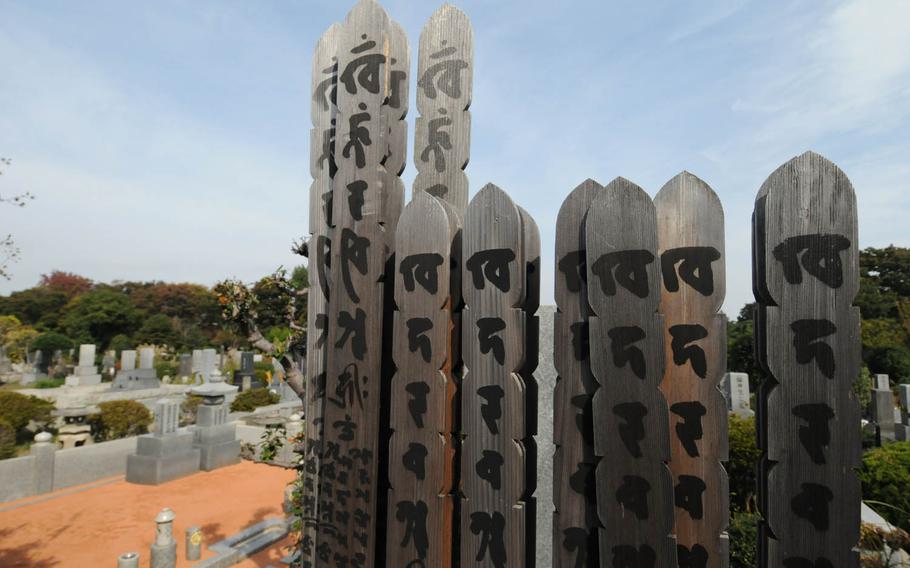 Sotoba, wooden sticks marked with a Buddhist prayer, adorn a grave at Tama Reien, a park-like cemetery in western Tokyo that holds the remains of hundreds of notable individuals.