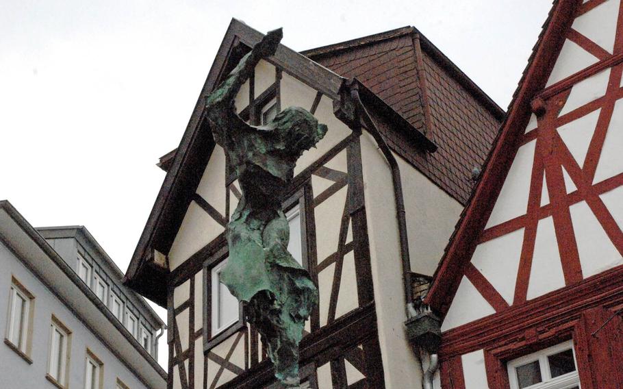 A sculpture  in Alzey, Germany, is set against a backdrop of the town's half-timbered houses.